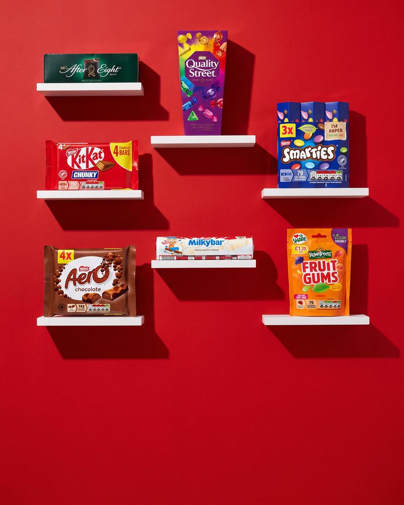 Wafer chocolate bars, chocolate tins and wrapped chocolates on a bright red background.